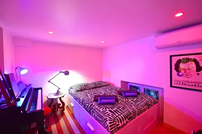 a pink room with a bed and a desk and a computer at DUPLEX 6 chambres Clim WIFI SAUNA Cannes in Cannes
