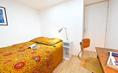 a bedroom with a bed and a desk and a lamp at DUPLEX 6 chambres Clim WIFI SAUNA Cannes in Cannes