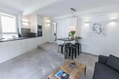 a living room and kitchen with a couch and a table at 2 pièces balcon 4 pers Meynadier Palais 1 minute by Olam Properties in Cannes