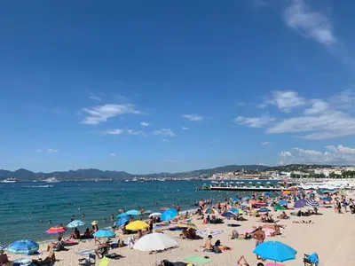 a crowd of people on a beach with umbrellas at Gray d'Albion - Cannes Rue d'Antibes - 2 Minutes walk from Beach, Palais des Festivals, Boulevard de la Croisette - Free Parking in Cannes