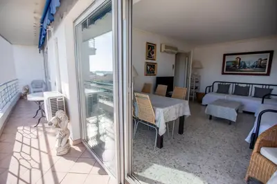 a living room with a table and a balcony at Very Nice View by Connexion in Cannes