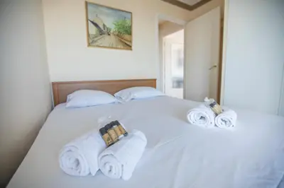 a bedroom with a white bed with towels on it at Very Nice View by Connexion in Cannes
