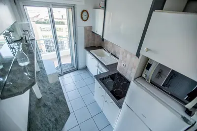a white kitchen with a sink and a microwave at Very Nice View by Connexion in Cannes