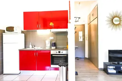 a kitchen with red cabinets in a room at ACCI Cannes Gallia in Cannes
