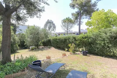 a yard with two chairs and a tree at Charming & bright flat with AC Garden 300m and Closed Garage - BENAKEY in Cannes