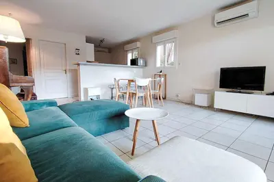 a living room with a blue couch and a tv at Charming & bright flat with AC Garden 300m and Closed Garage - BENAKEY in Cannes