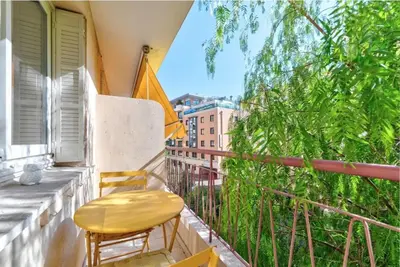 a balcony with two chairs and an umbrella at Agréable 3pièces Cannes Croisette in Cannes