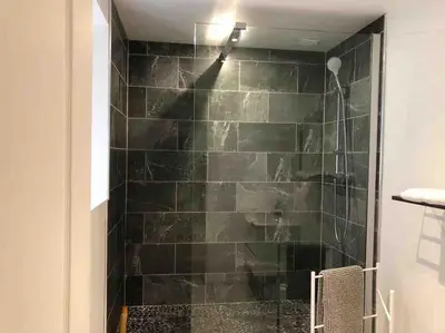 a shower with a green tiled wall in a bathroom at MARIE ANTOINETTE in Cannes