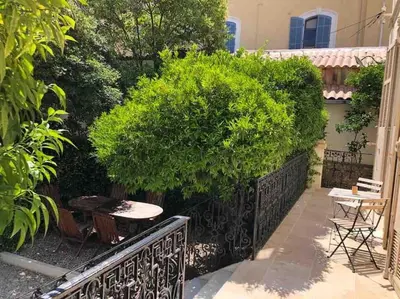 a small garden with a table and a bush at MARIE ANTOINETTE in Cannes