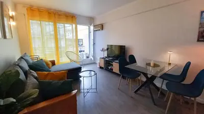 a living room with a couch and a table at Palais Carnot central apartment with balcony and A C in Cannes