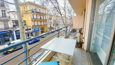 a table on a balcony with a view of a street at Palais Carnot central apartment with balcony and A C in Cannes