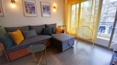 a living room with a couch and a window at Palais Carnot central apartment with balcony and A C in Cannes