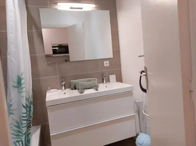 a bathroom with a white sink and a mirror at Studio Le Trident de la mer - Axelle Loc'Appart in Cannes