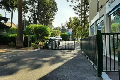 a gate in front of a building with a parking lot at Studio Le Trident de la mer - Axelle Loc'Appart in Cannes