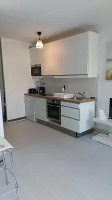 a kitchen with white cabinets and a sink at Studio Le Trident de la mer - Axelle Loc'Appart in Cannes