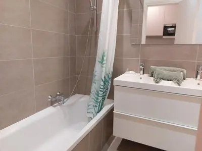 a bathroom with a sink and a bath tub and a shower curtain at Studio Le Trident de la mer - Axelle Loc'Appart in Cannes