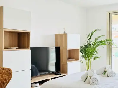 a bedroom with a tv and a bed with towels at CannesAzur - Appartement Terrasse centre Cannes in Cannes