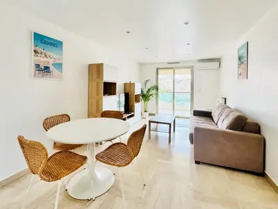 a living room with a table and chairs and a couch at CannesAzur - Appartement Terrasse centre Cannes in Cannes