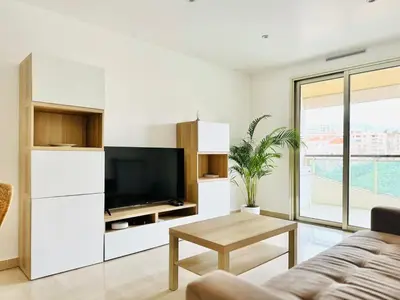 a living room with a couch and a tv at CannesAzur - Appartement Terrasse centre Cannes in Cannes