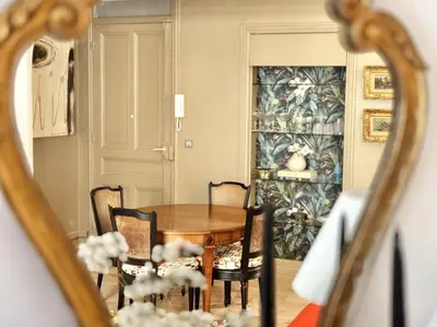 a dining room with a table and chairs and a mirror at L’app’Art Cannes - Contemporain Centre-Ville in Cannes
