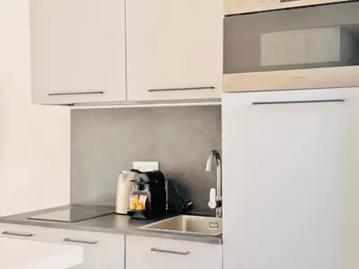 a kitchen with white cabinets and a sink at Le Bohème - Logement Cozy centre in Cannes