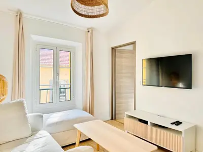 a living room with a couch and a tv at Le Bohème - Logement Cozy centre in Cannes