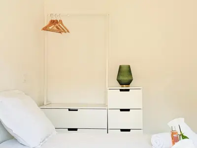 a white bedroom with a bed and a green vase at Le Bohème - Logement Cozy centre in Cannes
