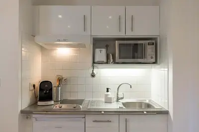 a white kitchen with a sink and a microwave at Studio Alexandre - Cannes in Cannes