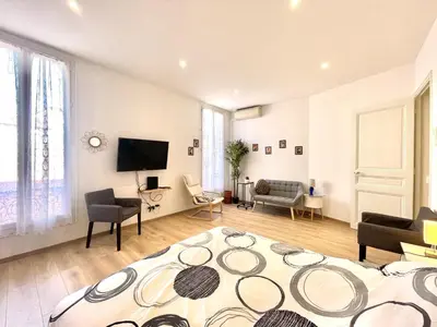 a living room with a large bed and a tv at Woody old town appartement by Welcome to Cannes in Cannes