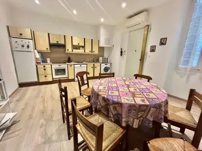 a kitchen with a table and some chairs and a table and a kitchen at Woody old town appartement by Welcome to Cannes in Cannes