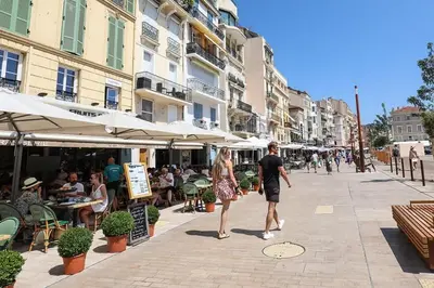 a man and a woman walking down a street at LA PERLE au cœur du centre ville, idéal pour séjours loisirs ou business in Cannes
