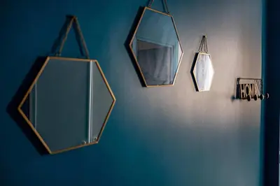 a group of mirrors hanging on a blue wall at LA PERLE au cœur du centre ville, idéal pour séjours loisirs ou business in Cannes