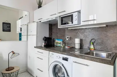 a kitchen with a sink and a washing machine at LA PERLE au cœur du centre ville, idéal pour séjours loisirs ou business in Cannes