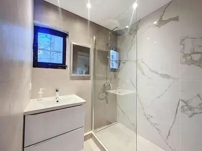 a kitchen with white cabinets and a sink and a microwave at Joli studio Cannes marché forville in Cannes