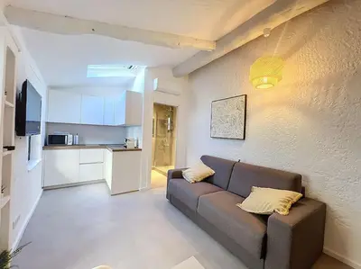 a kitchen with white cabinets and a microwave at Joli studio Cannes marché forville in Cannes