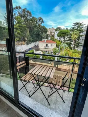 a balcony with a wooden bench and a table at Cocon Riviera in Cannes