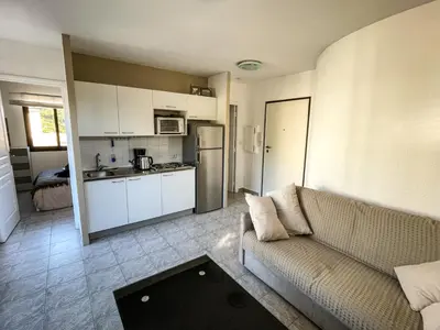 a living room with a couch and a kitchen at Cocon Riviera in Cannes