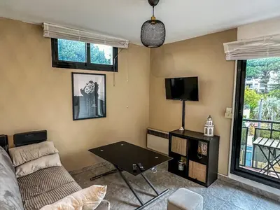 a living room with a couch and a tv at Cocon Riviera in Cannes