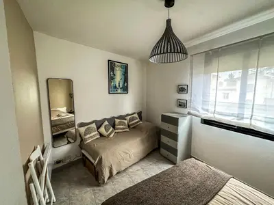 a small bedroom with a bed and a mirror at Cocon Riviera in Cannes