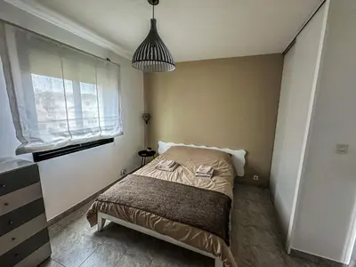a bedroom with a bed and a pendant light at Cocon Riviera in Cannes