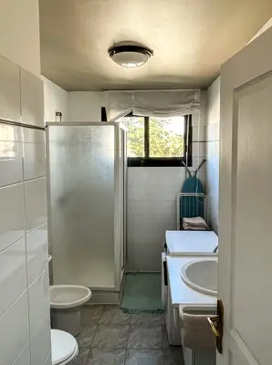 a bathroom with a shower and two sinks and a toilet at Cocon Riviera in Cannes