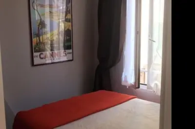 a bedroom with a bed with a red blanket and a window at Casa Charlotte nel cuore di Cannes in Cannes
