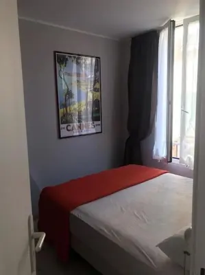 a bedroom with a bed with a red blanket and a window at Casa Charlotte nel cuore di Cannes in Cannes
