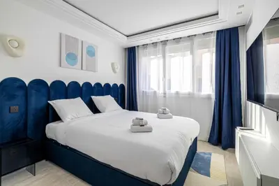 a bedroom with a large bed with a blue headboard at Luxurious Apartment- Croisette-Carré d'Or in Cannes