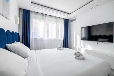 a white room with a bed and a tv at Luxurious Apartment- Croisette-Carré d'Or in Cannes