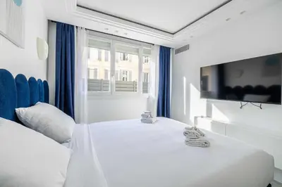 a bedroom with a white bed and a large window at Luxurious Apartment- Croisette-Carré d'Or in Cannes
