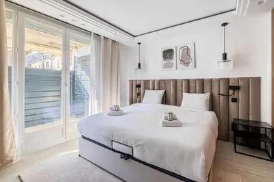 a bedroom with a large bed and a large window at Luxurious Apartment- Croisette-Carré d'Or in Cannes