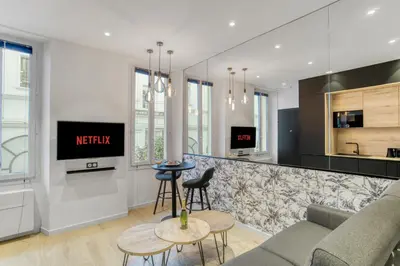 a living room with a couch and a kitchen at 1 Chambre Modern D - Calme - Hypercentre à 2 minutes du palais in Cannes