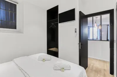 a bedroom with a white bed and a black door at 2 Chambre Modern - Proche palais - Spacieux - Calme in Cannes