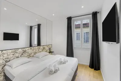 a bedroom with a bed and a window and a tv at 2 Chambre Modern - Proche palais - Spacieux - Calme in Cannes